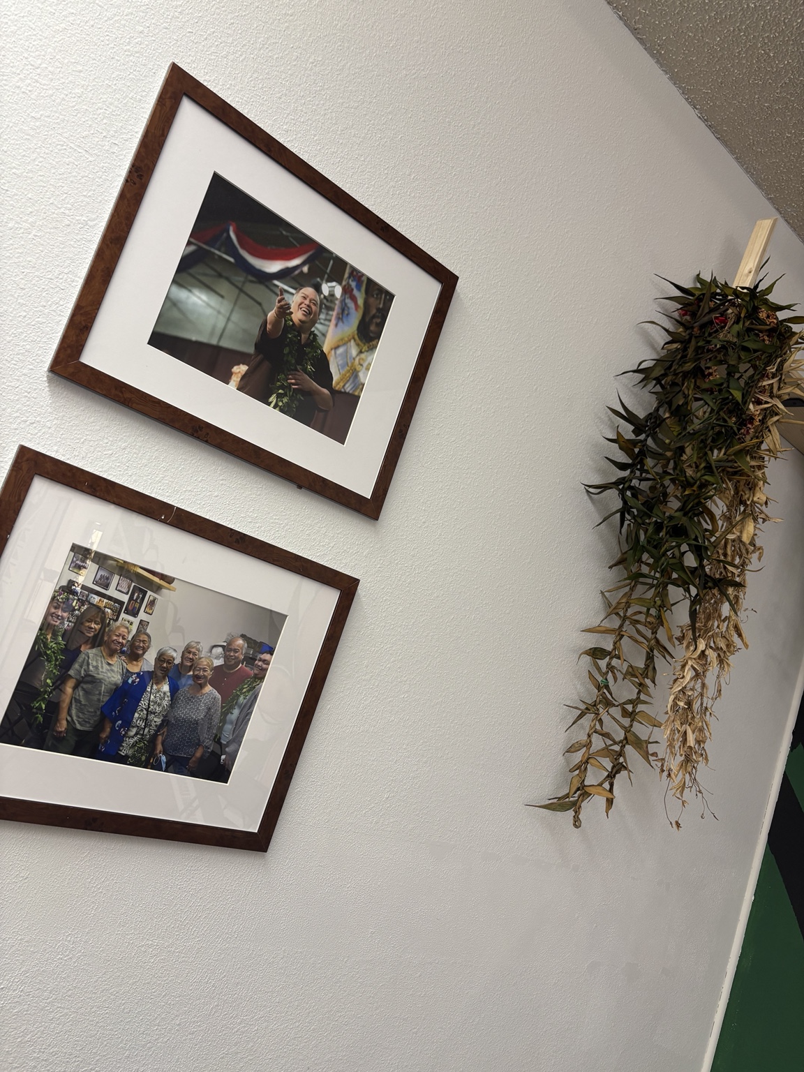 Cultural photographs and lei displayed at the hālau